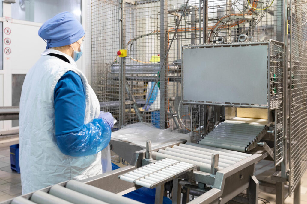 Checkweigher pada conveyor untuk memeriksa berat kemasan produk pangan.