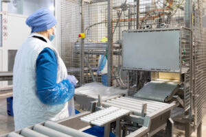 Checkweigher pada conveyor untuk memeriksa berat kemasan produk pangan.